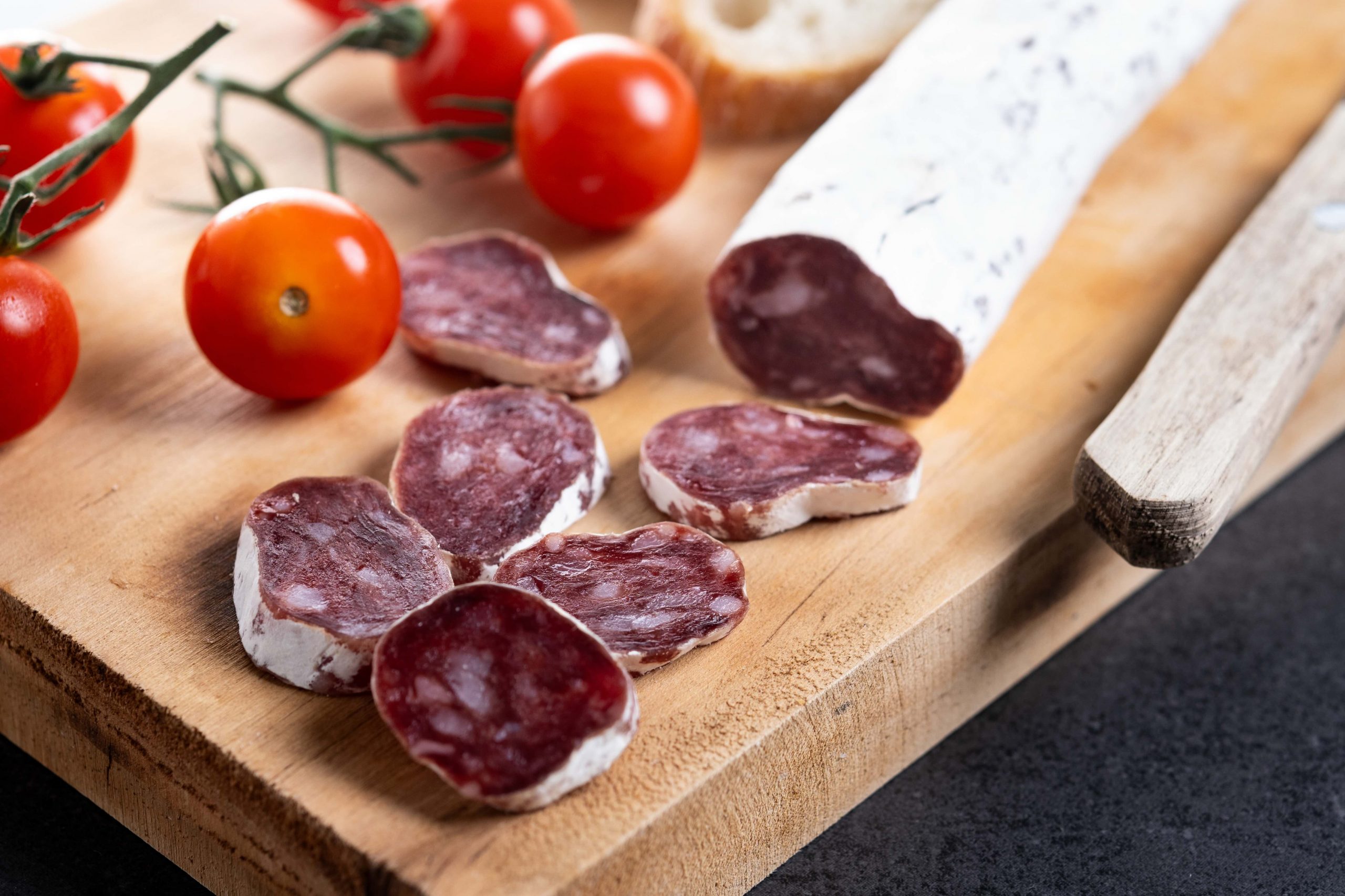 Fuet.Dry cured fuet sausage on black background.